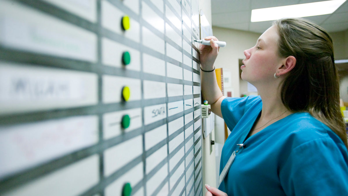 Nicole Hoppe, RN, checks the Status Board at a nurses' station on medical surgical floor of Seton Northwest Hospital, Austin, Texas. Transforming Care at the Bedside.