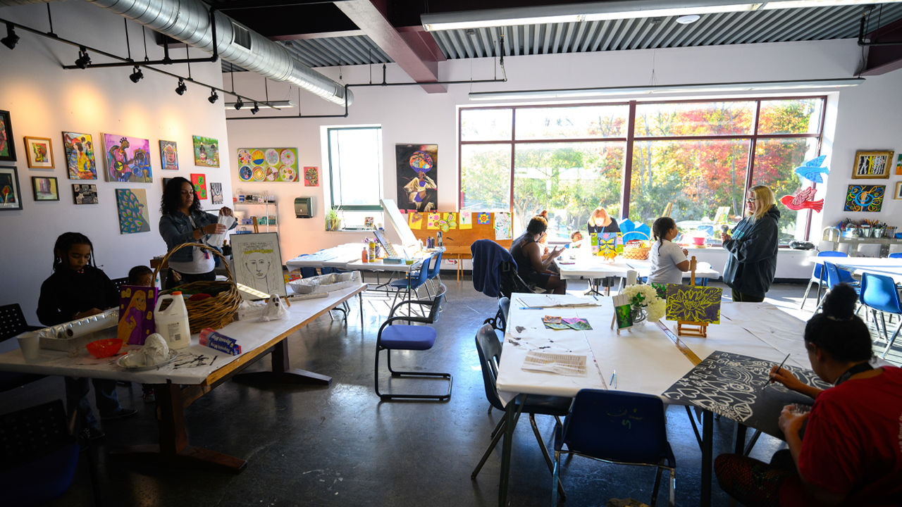 Families participating in an art class in a studio.