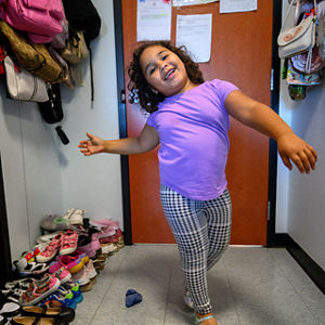 A young girl shows of her dress shoes.