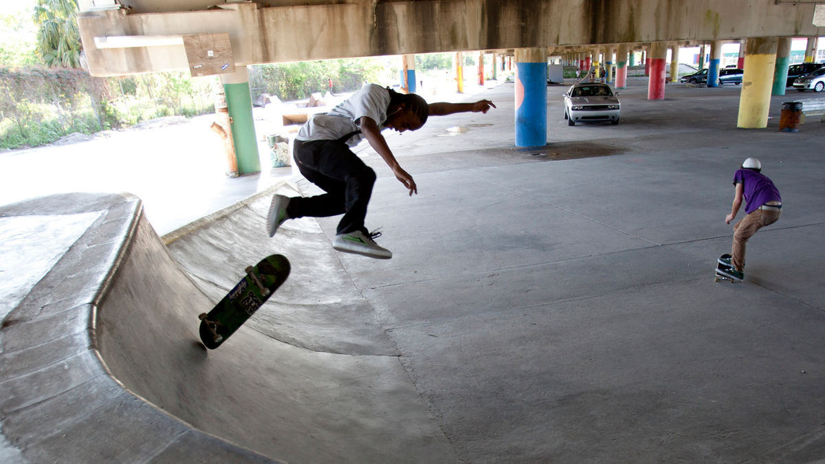 Youth using a public skateboard ramp underneath the I-610 overpass.