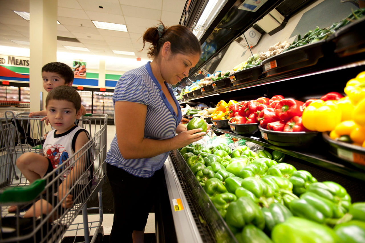 A woman shops for fresh produce in a grocery store.