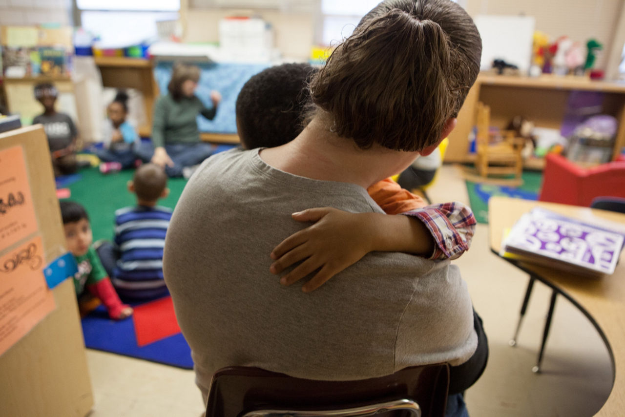 A teacher holding a student during class.