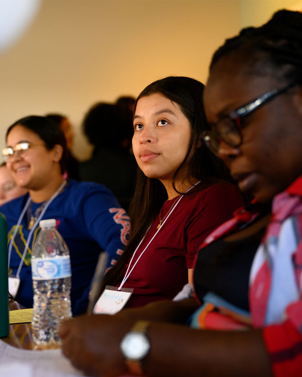 A row of women sitting behind a conference table.