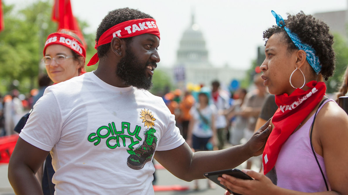 Multiracial activists gather on a city street to support a cause.