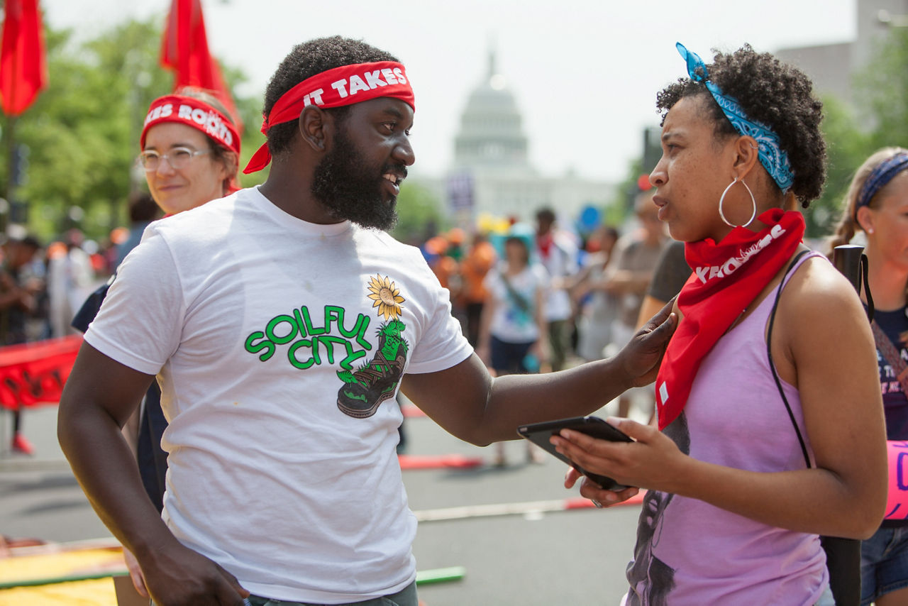 Multiracial activists gather on a city street to support a cause.