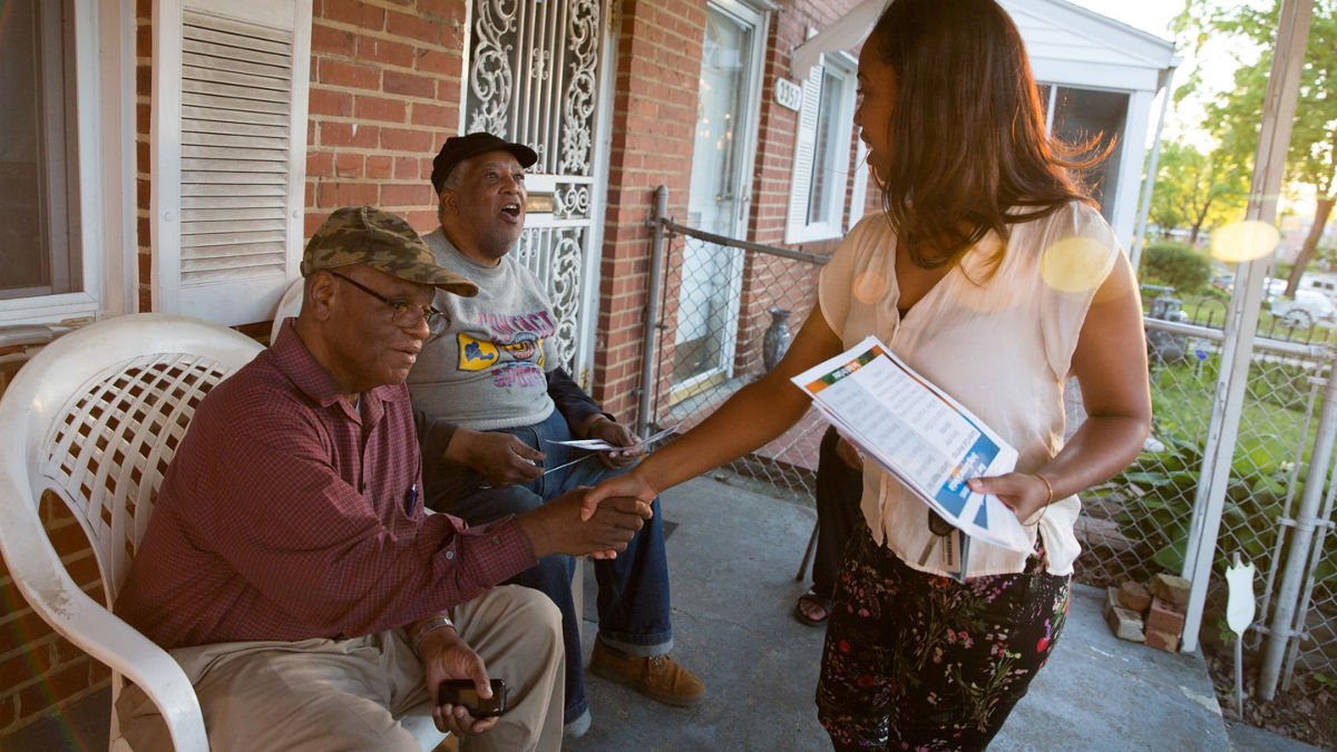 RWJF Community Health Leader Joelle Robinson passing out flyers about the garden club that she runs.