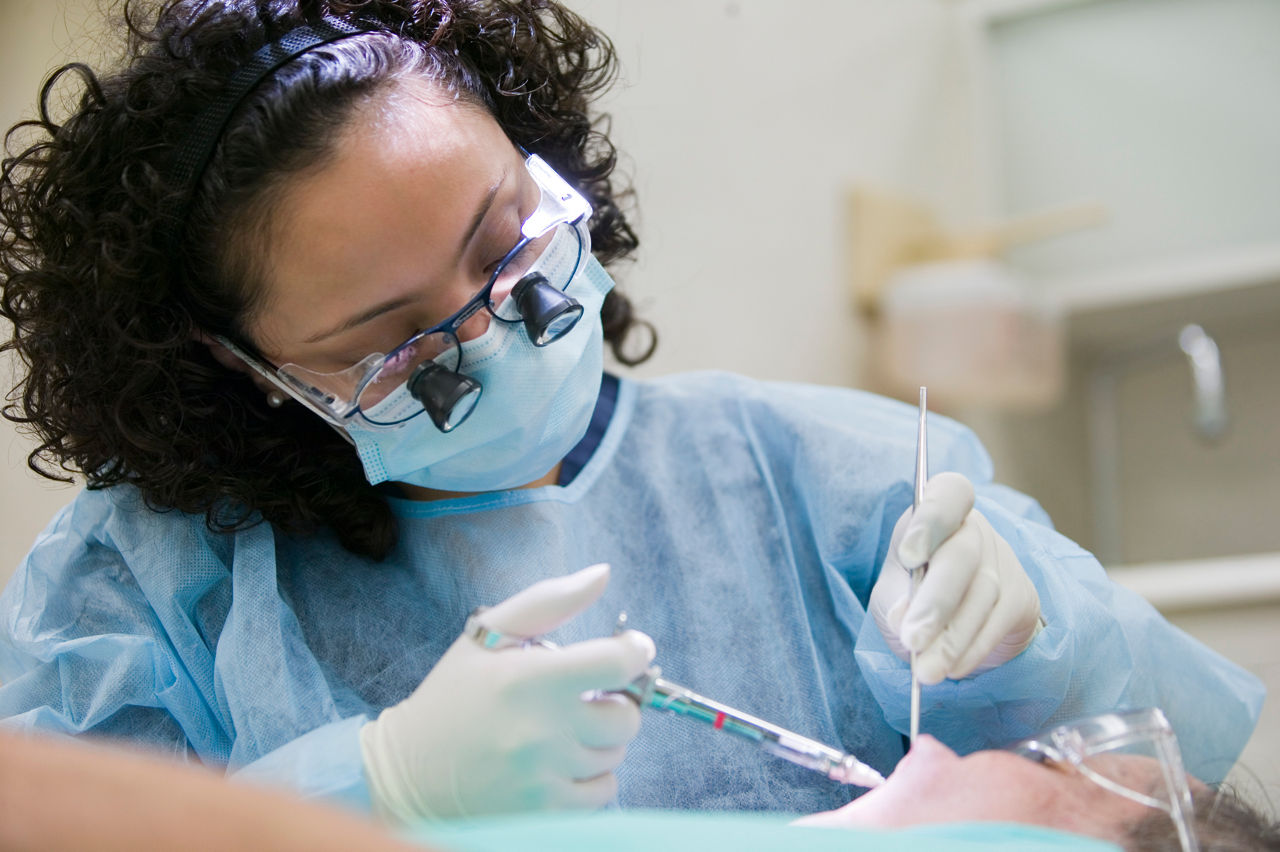 Esther Lopez, dental student at the University of Illinois at Chicago, performing an oral procedure.  Pipeline, Profession and Practice: Community Based Dental Education