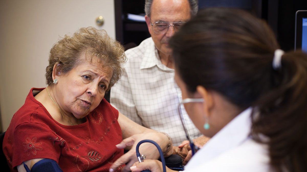 A doctor takes a patient's blood pressure during an office visit.
