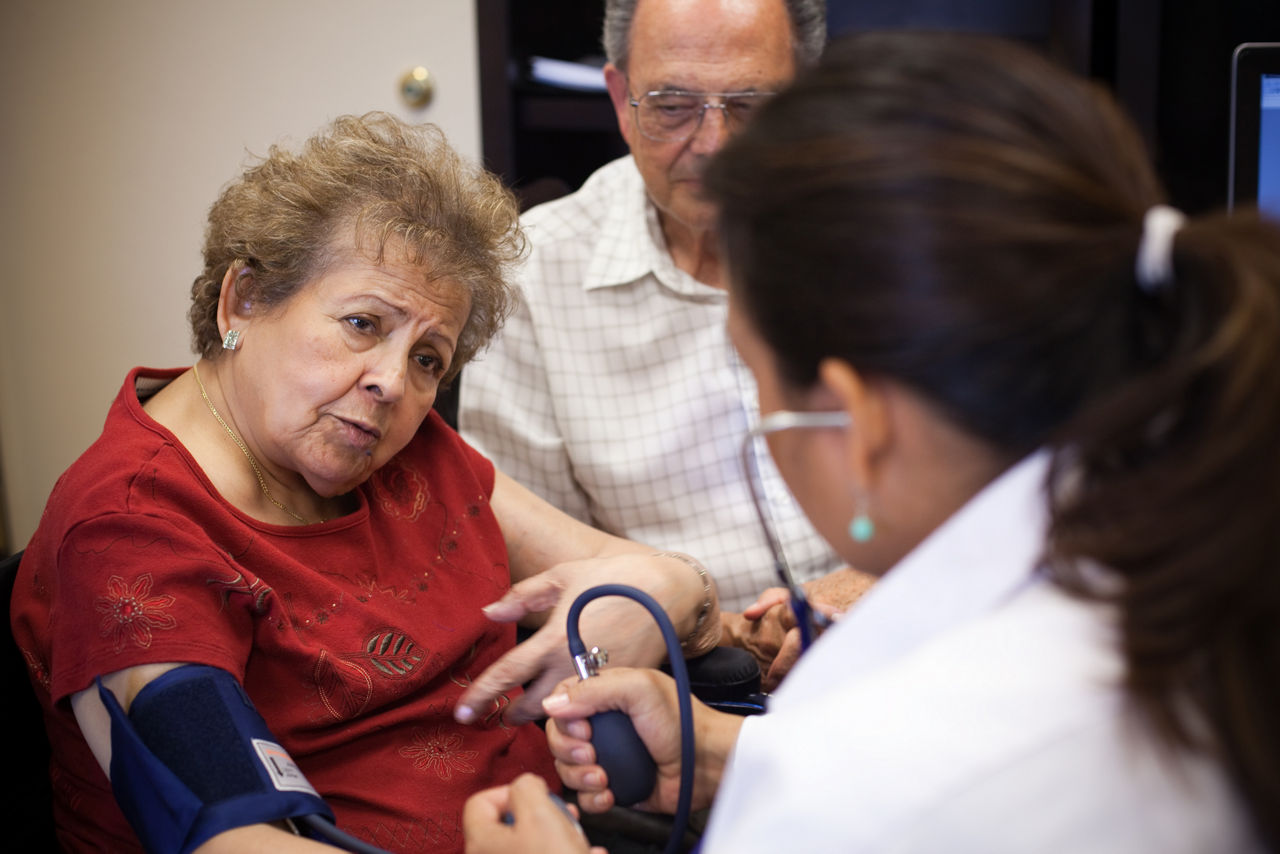 A doctor takes a patient's blood pressure during an office visit.