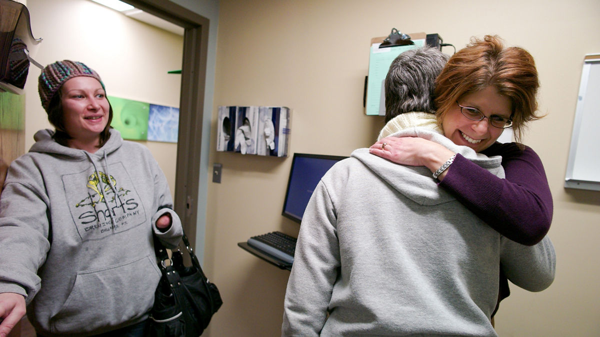 Anna Piscopo (slender, glasses, white knit scarf) visits with both Scott Haga, the PA and Shelly Virva, the social worker. Anna is accompanied by her daughter, Roberta Earl. This is an emotional day for Anna as she is preparing to begin chemo next week and evidently this is just one of her many battles. She has been alcohol free for 17 years, she said proudly.
