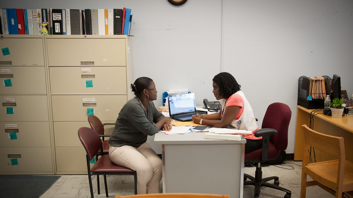 Marie Monica Ulysse, right, a counselor at the Joint Committee for Children's Healthcare in Everett, speaks with client Hermione Saint-Hilaire. The Joint Committee focuses on connecting Everett's citizens with the health services available to them.