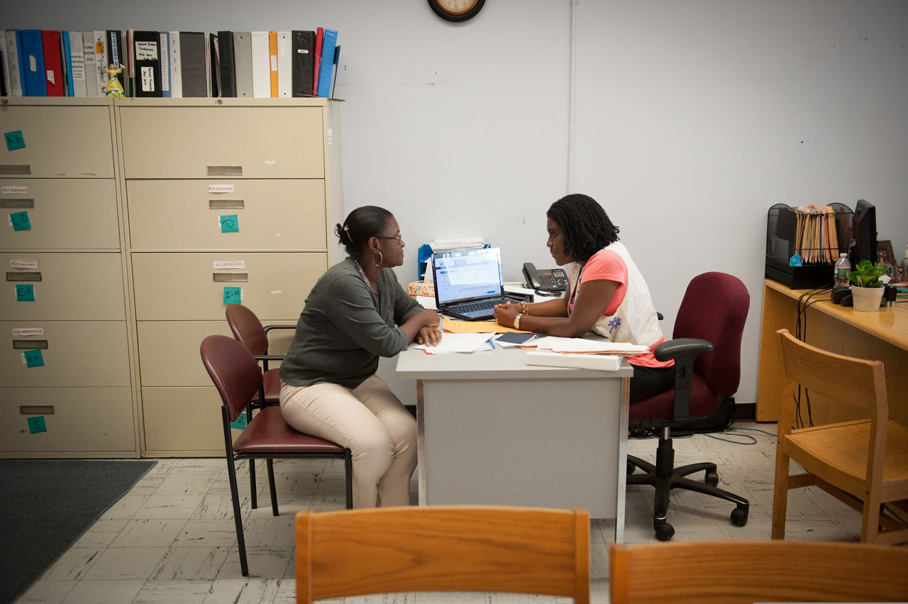 Marie Monica Ulysse, right, a counselor at the Joint Committee for Children's Healthcare in Everett, speaks with client Hermione Saint-Hilaire. The Joint Committee focuses on connecting Everett's citizens with the health services available to them.