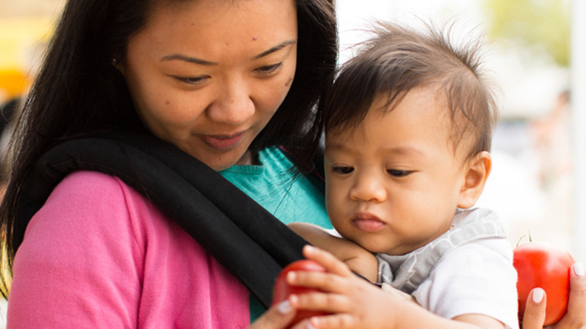 A woman and her baby at a farmers' market.