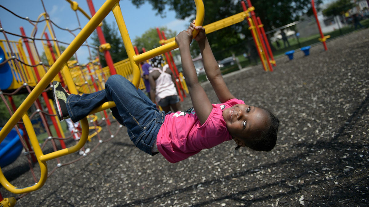 Five-year-old Serenity Ferrell plays on the jungle gym in Philadelphia's Hunting Park on Saturday, June 11, 2016. The playground was the first of several to be erected as a result of the efforts of football coach Leroy "Chuck" Fisher and community organization Hunting Park United, which have set off a renaissance in the park over the last decade.