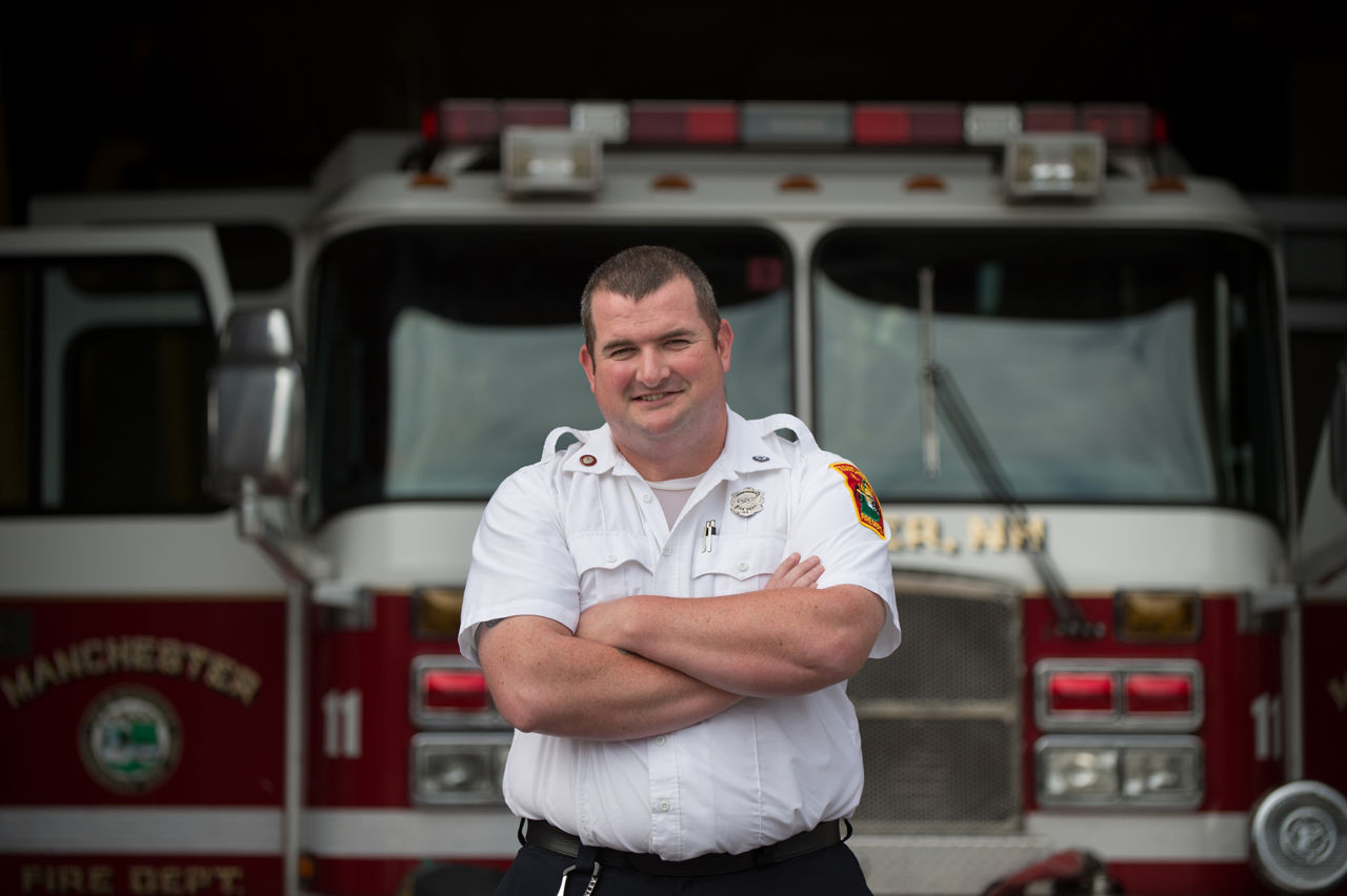 Firefighter Christopher Hickey stands in front of Central Fire Station in Manchester, N.H. on Thursday, Aug. 18, 2016.