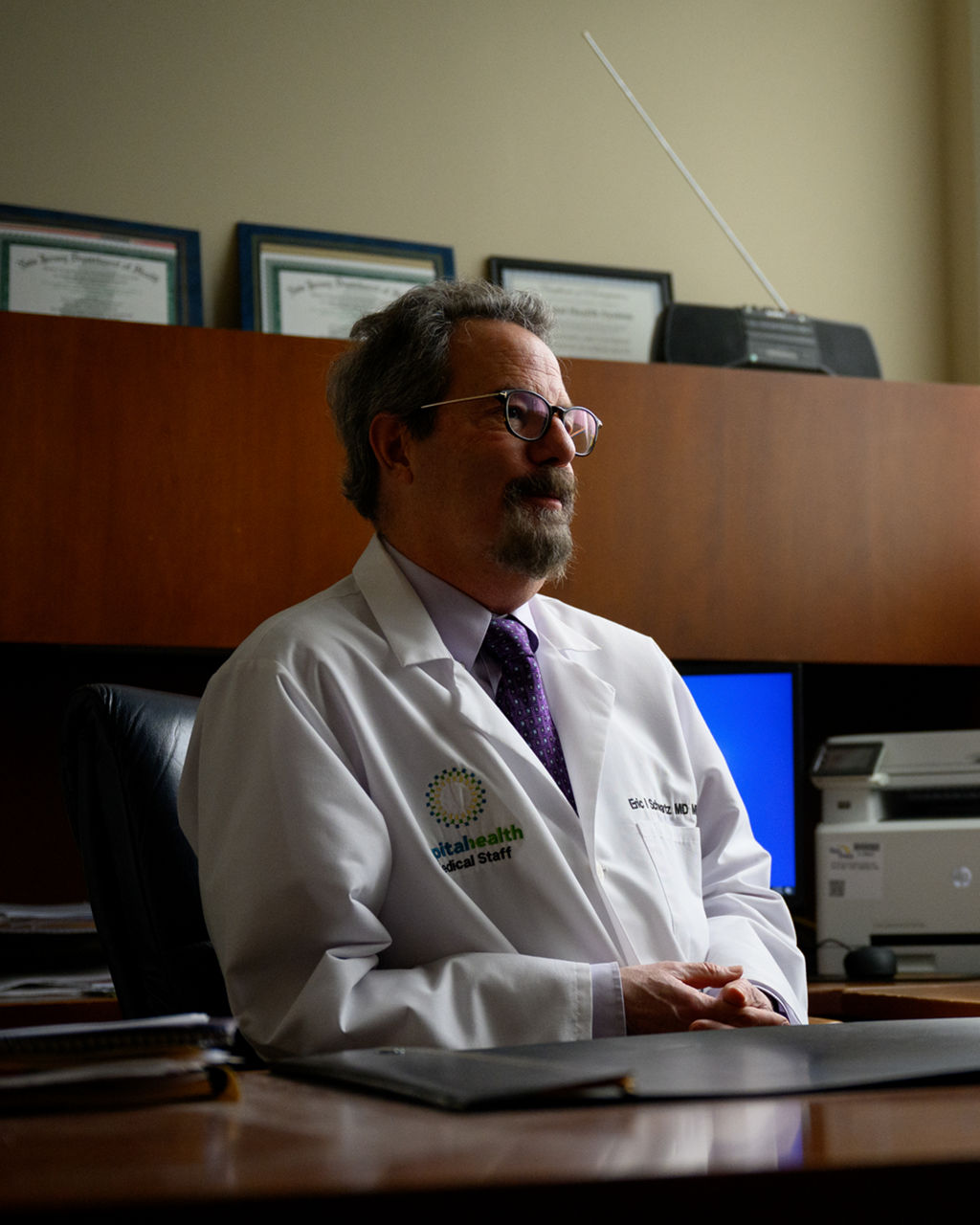A doctor sitting at a desk in his office.