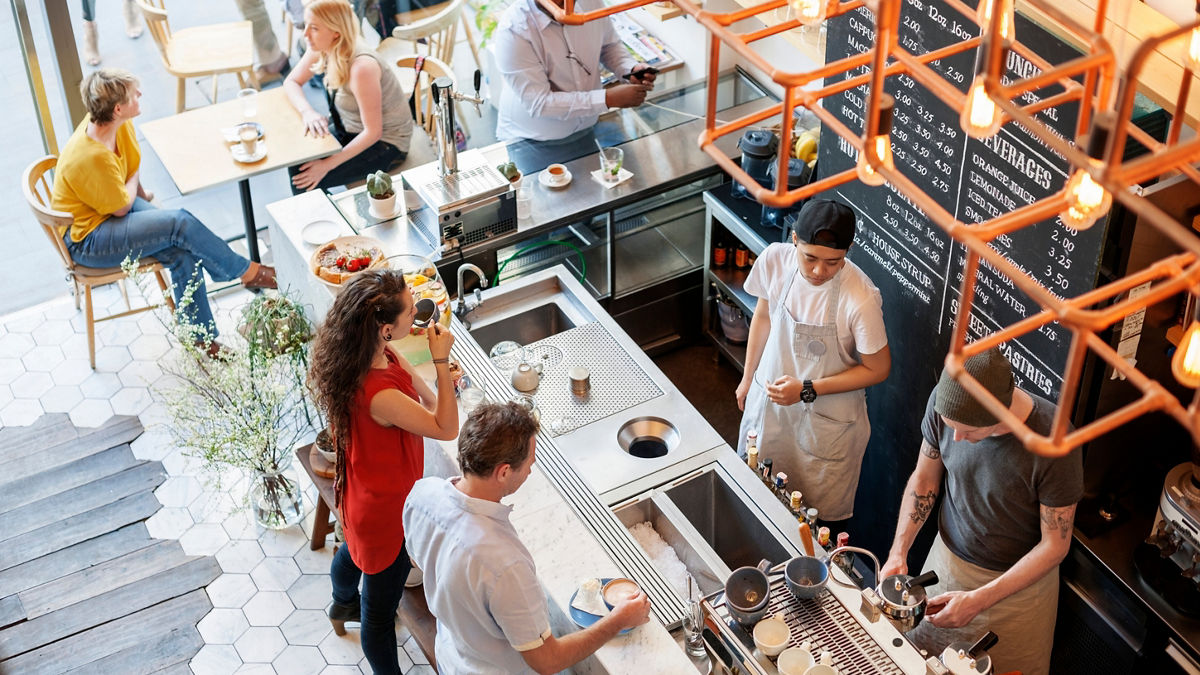 A birds eye view of people standing in a coffee shop.