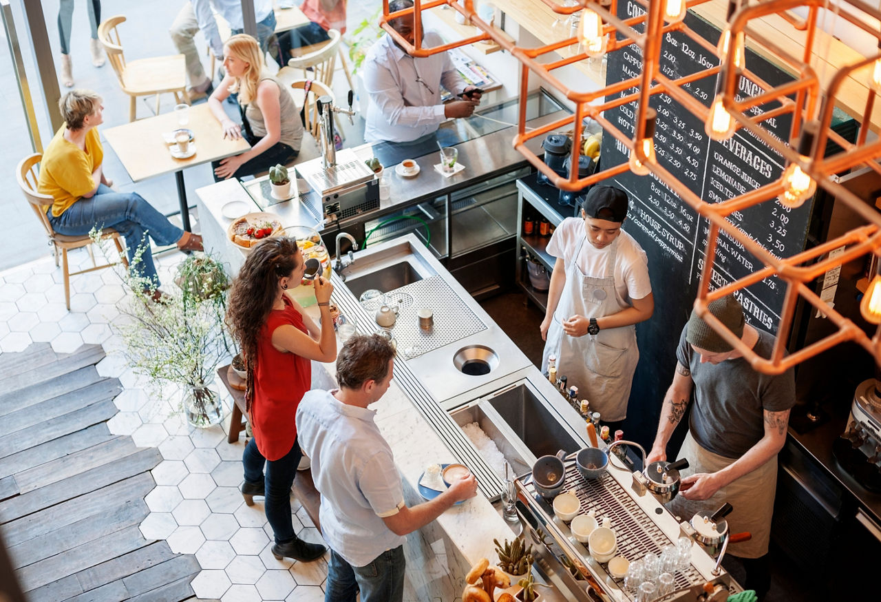 A birds eye view of people standing in a coffee shop.