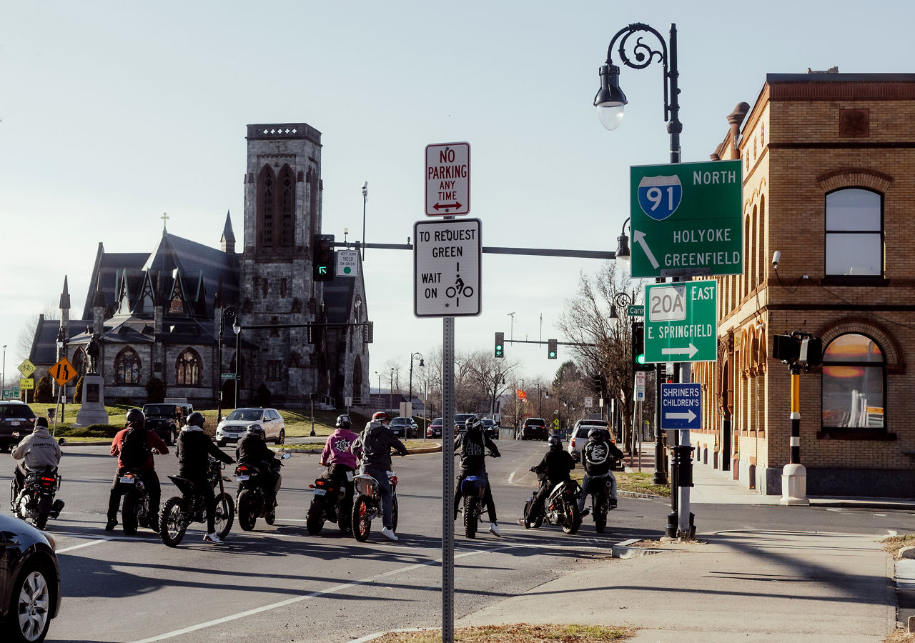 A biker group stopped at a traffic light.