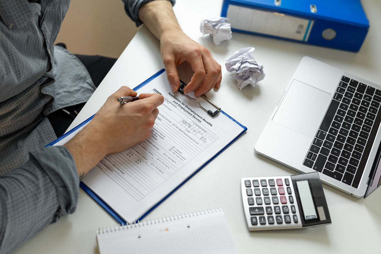 A man completing a claim form on a clipboard.