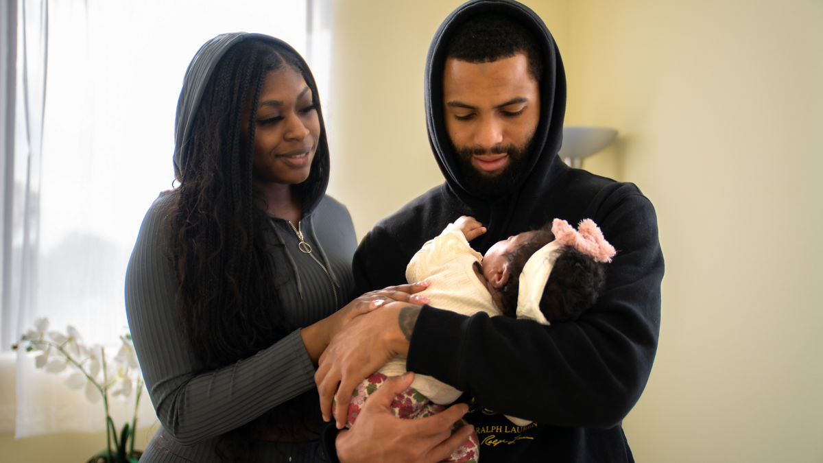 Parents look adoringly at their newborn child.