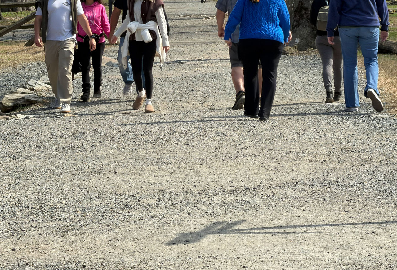 People walking on gravel depicts the sharing of space.