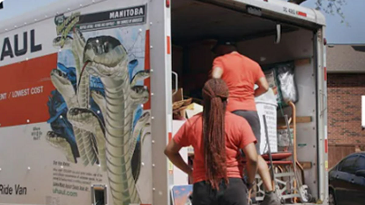 Two women loading a moving van.