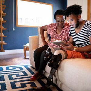 Son/Grandson using digital tablet with his mother/grandmother