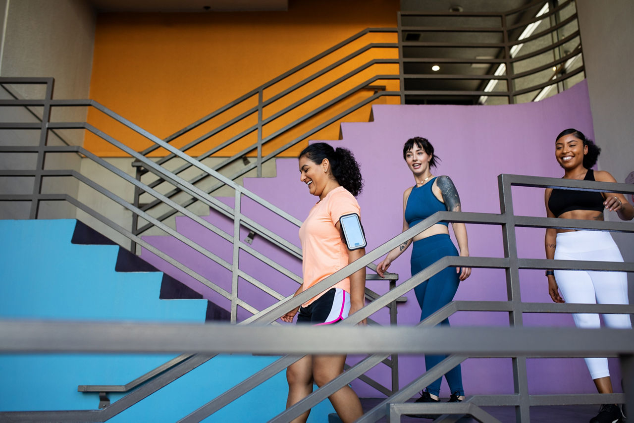 Group of multi-ethnic women walking down the stairs of gym. 