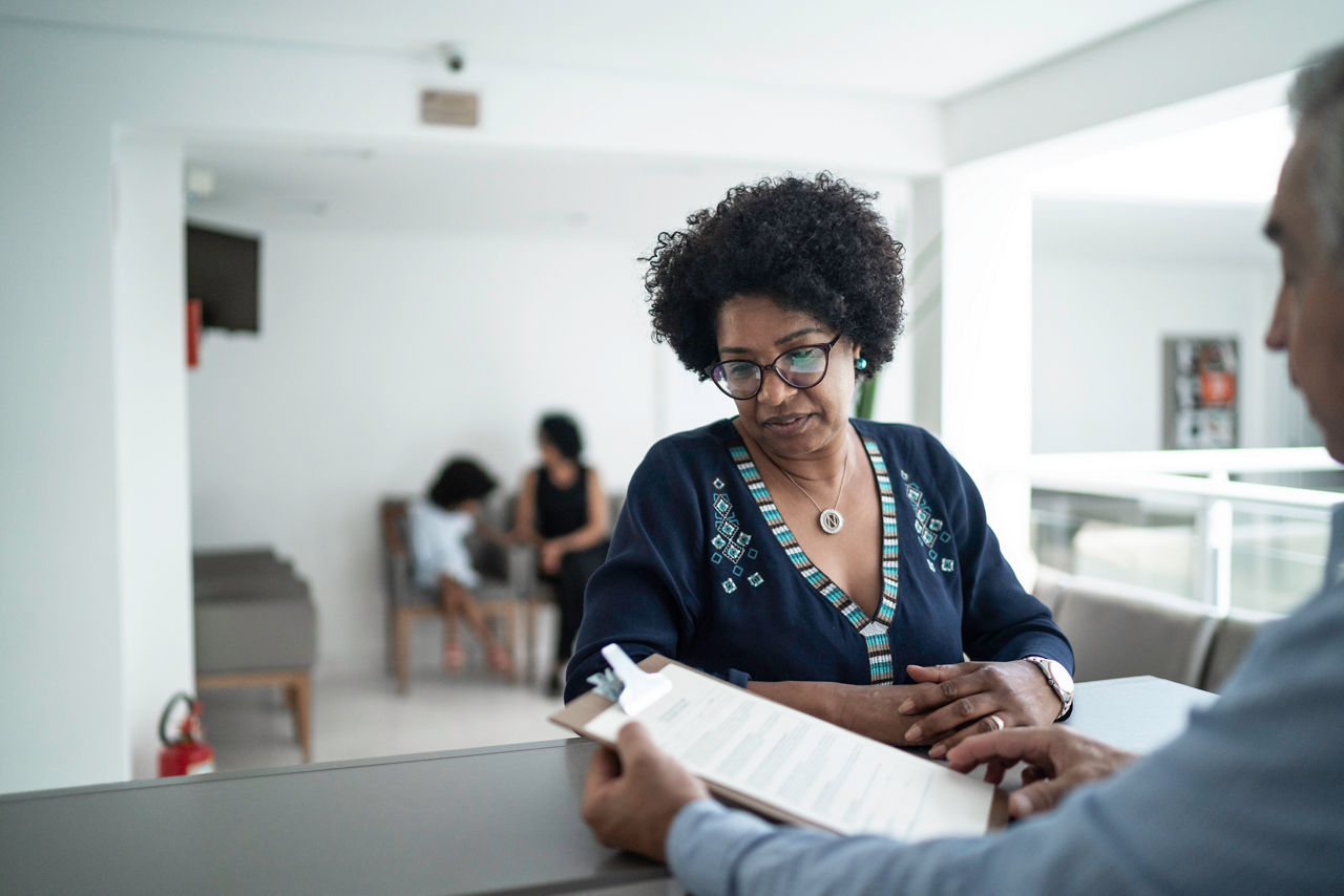 Patient talking to the secretary at hospital reception