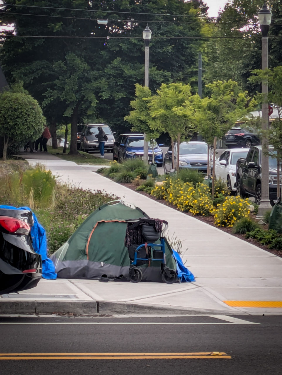 Tents along a sidewalk where unhoused people live.