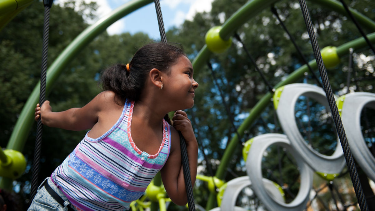 Valerie De Los Santos, 6, climbs on the jungle gym in the new playground in Lawrence's Campagnone Common on a Sunday afternoon.