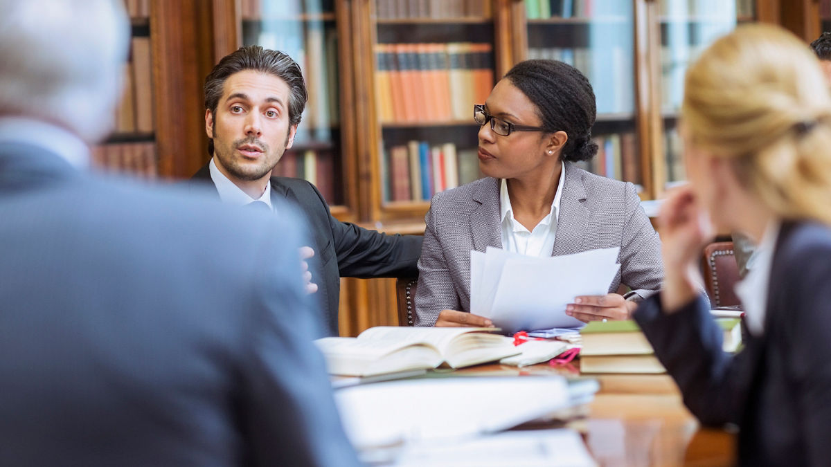 A group of professionals discuss research findings during a meeting.