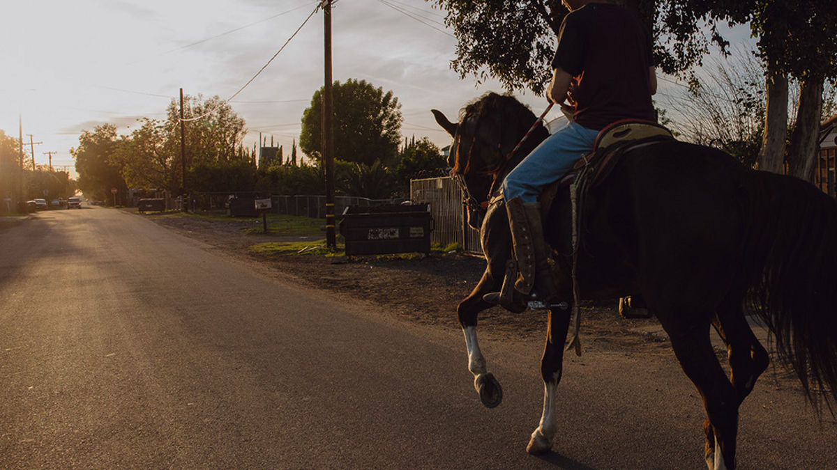Riding a horse through a community