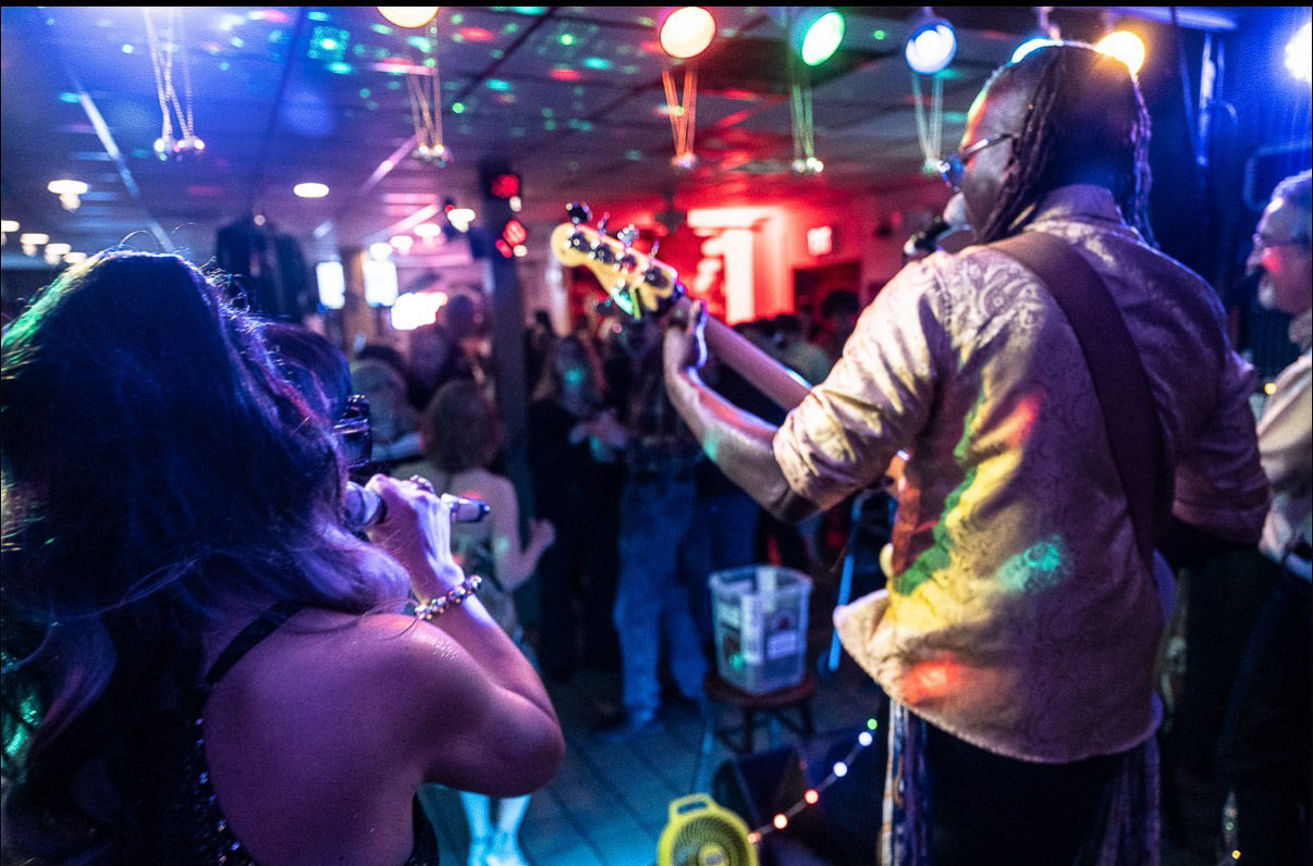 A musician playing with bandmates at a club. 