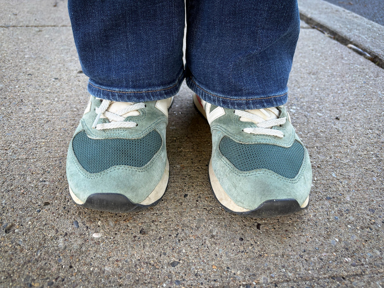 A photo of someone's feet inside teal-colored running shoes.