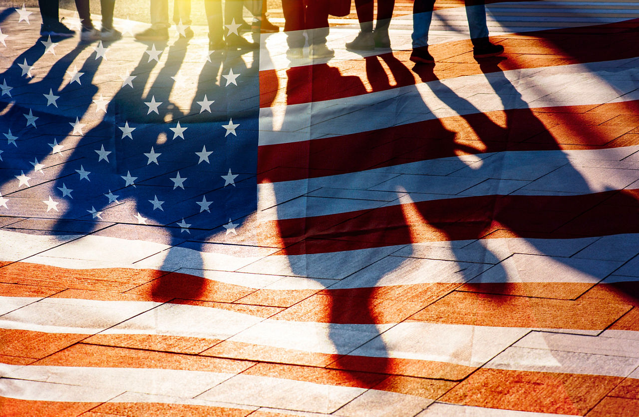 Shadows cast against an American flag, highlighting the concept that some people exist, but are often not fully seen. 