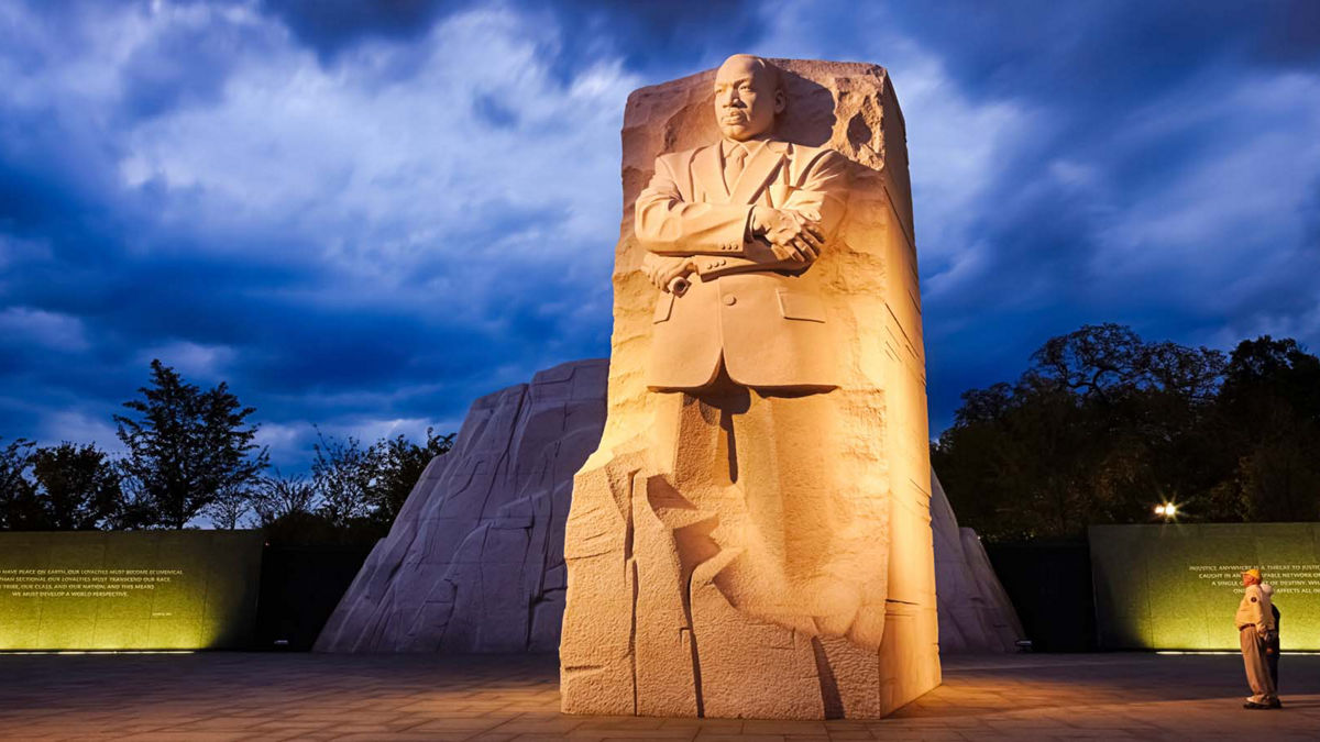 Two people looking at the MLK Memorial in DC at twilight.