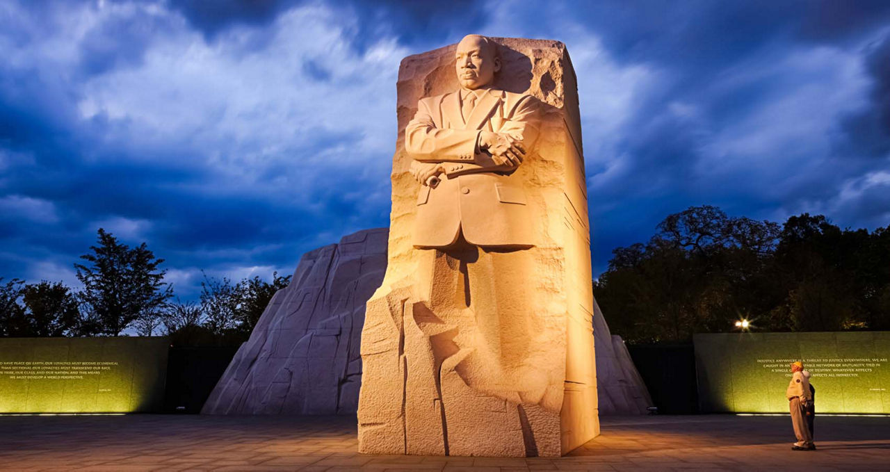 Two people looking at the MLK Memorial in Washington DC at twilight.