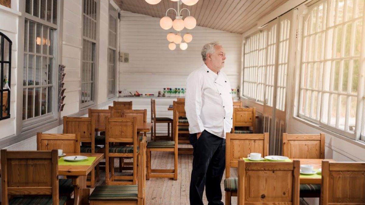 Man standing in empty restaurant.