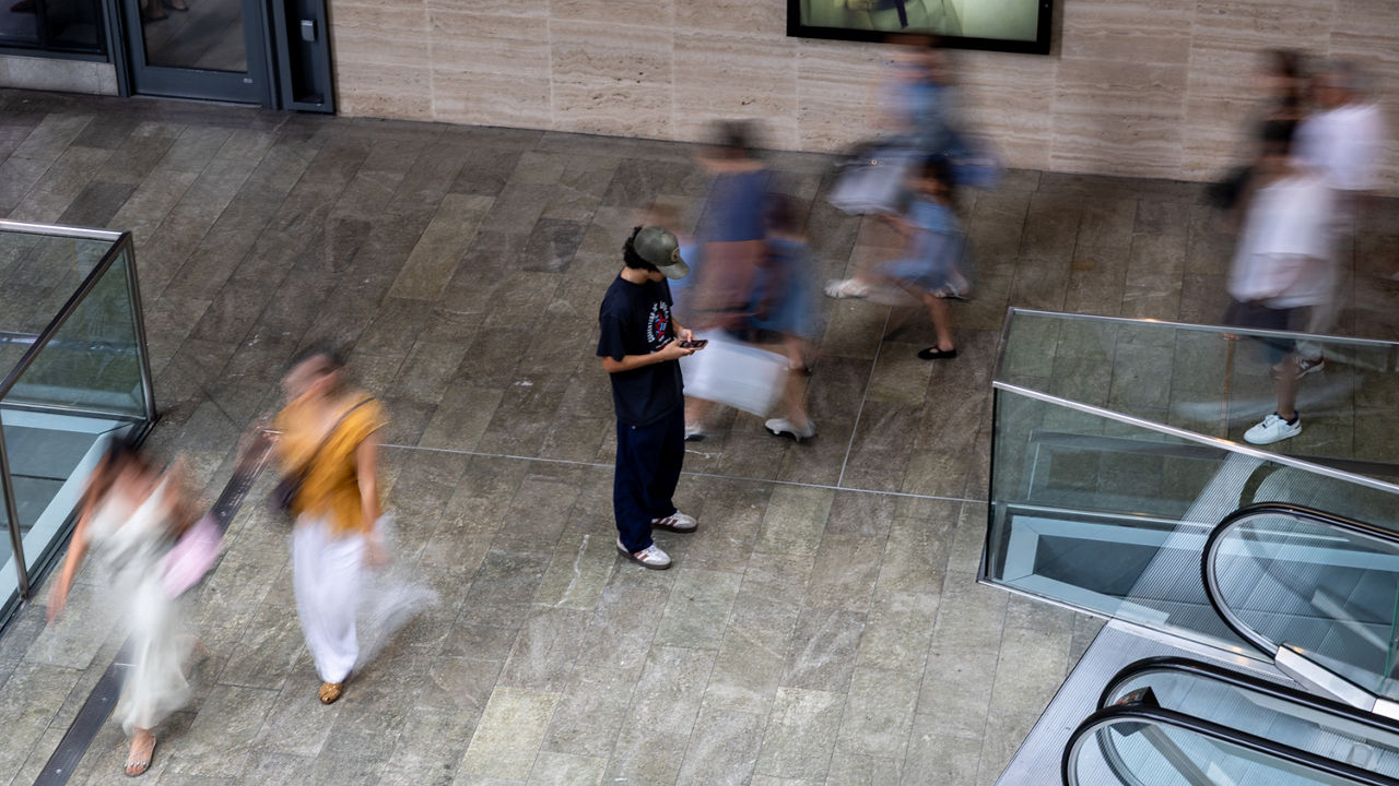 A person standing still among others scurrying past.
