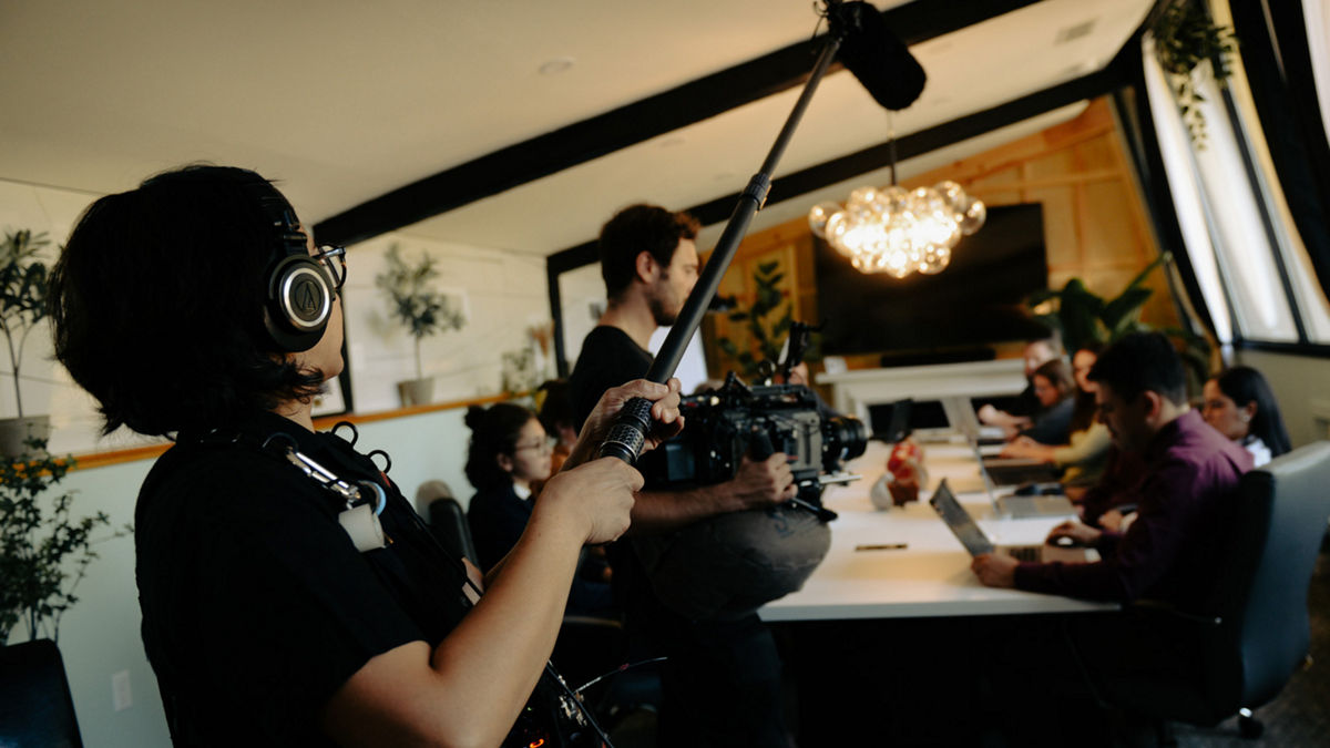 An AV crew recording audio during a meeting.