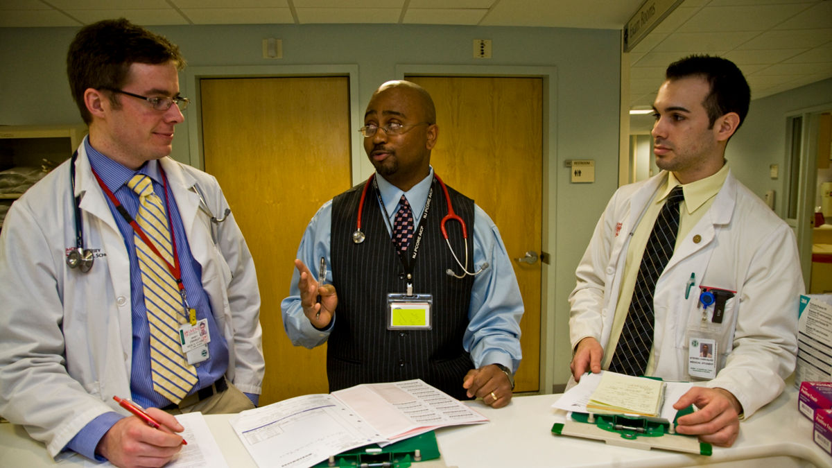  Three doctors collaborating about patient care.