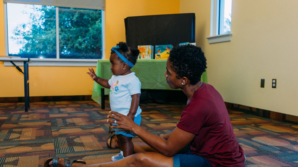 A mother and toddler attending a workshop at a library.