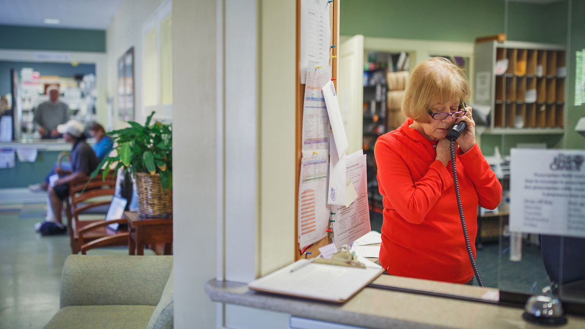 A receptionist answers the phone at a free clinic.