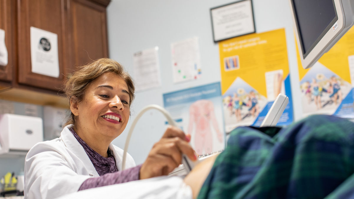 A medical professional gives a sonogram.