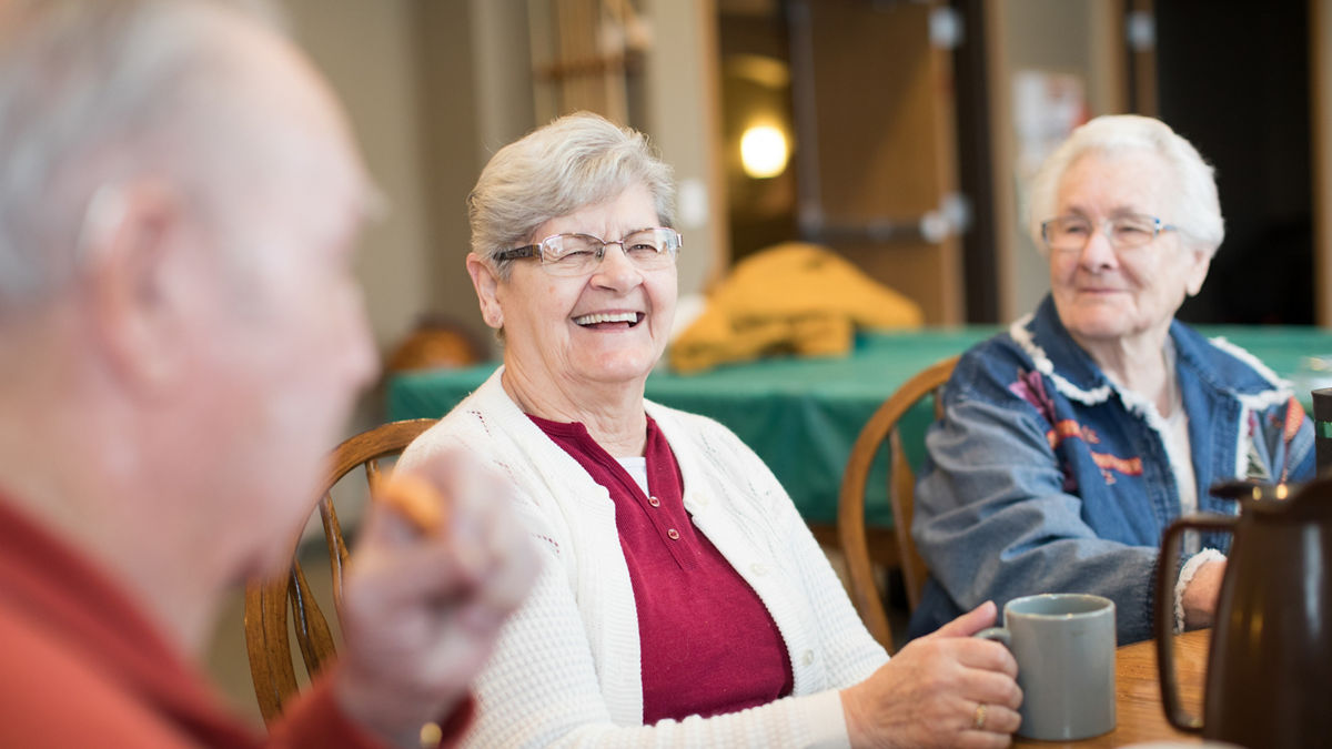 Older adults enjoying comradery in recreation room.