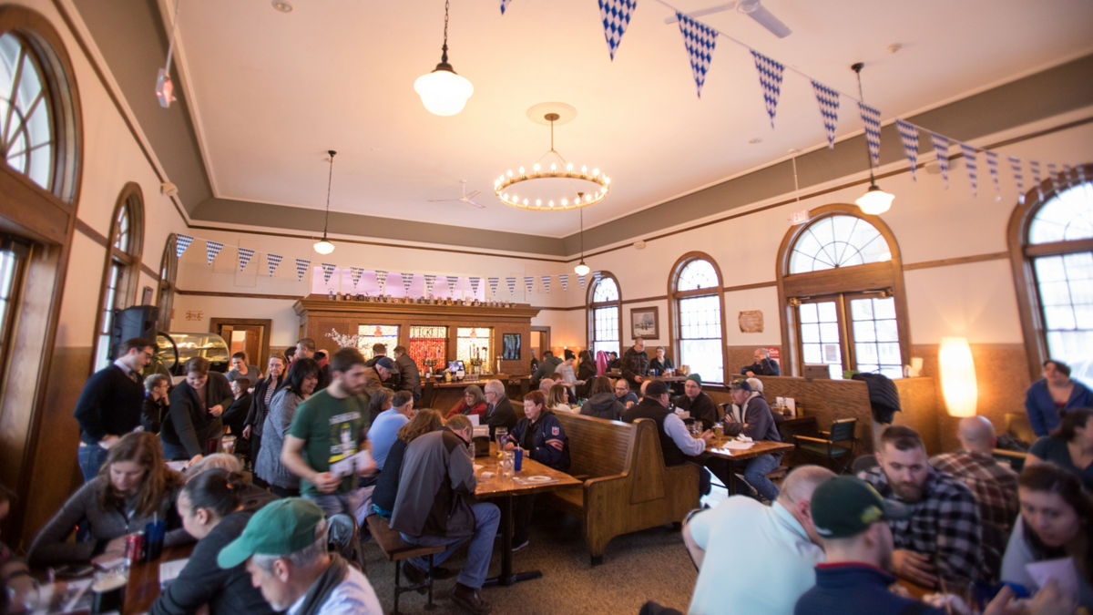Neighborhood residents participating in a town meeting inside a restaurant.