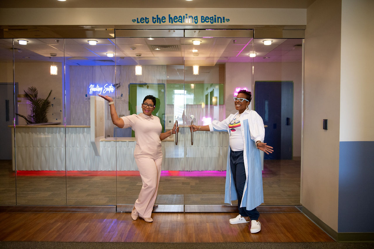 Two smiling women welcome children to a trauma center.