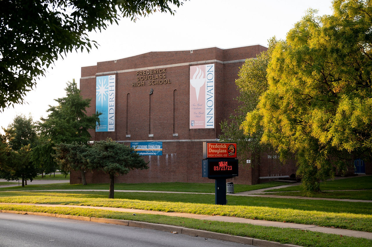 A high school building surrounded by green grass and trees. 